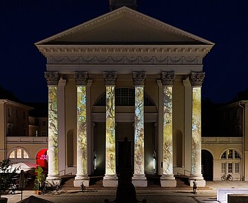 Ev. Stadtkirche Karlsruhe bei Nacht mit Medienkunstprojektion auf den Säulen