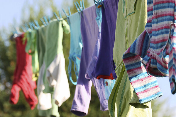 Das Bild zeigt bunte Wäsche auf der Wäscheleine.