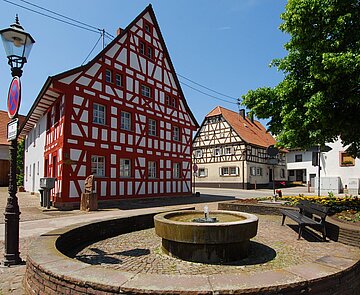 Ein Brunnen vor einem Fachwerkhaus