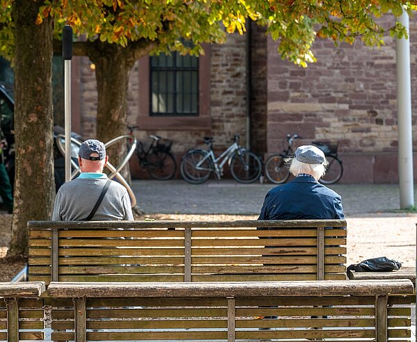Zwei Personen sitzen auf einer Bank auf dem Stephanplatz.