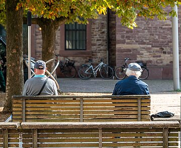 Zwei Personen sitzen auf einer Bank auf dem Stephanplatz.