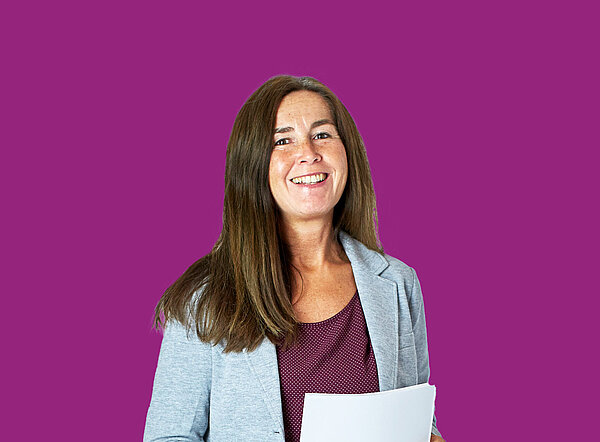 Frau steht mit Dokumenten in der Hand vor lila Hintergrund