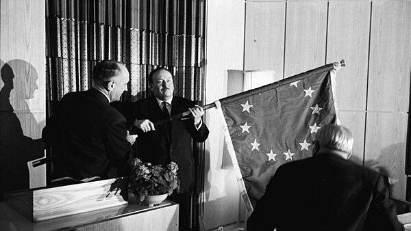 Der Präsident des Kommunalausschusses der Beratenden Versammlung des Europarates Dr. Henra Cravatte (links) bei der Übergabe der Europafahne an Oberbürgermeister Günther Klotz.