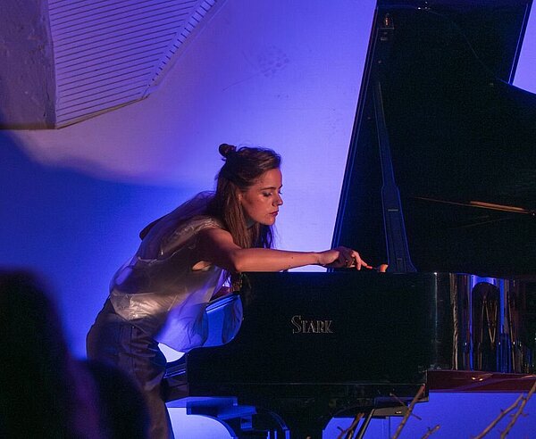 Musikerin spielt an Piano