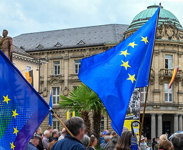 Menschen schwenken Europafahnen auf dem Marktplatz