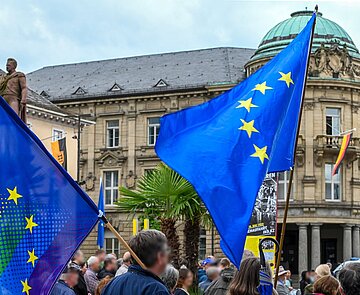Menschen schwenken Europafahnen auf dem Marktplatz