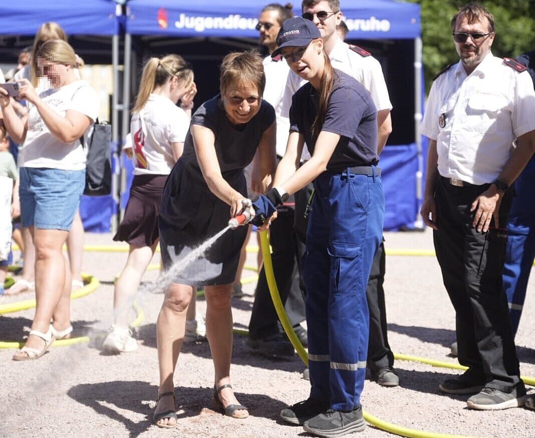 Erste Bürgermeisterin Bettina Lisbach informiert sich beim Rundgang über das Jubiläumsfest der Berufsfeuerwehr Karlsruhe unter anderem an der Station der Jugendfeuerwehr über die vielfältigen Aufgaben der Blaulichtorganisationen und darf auch selbst Hand anlegen.