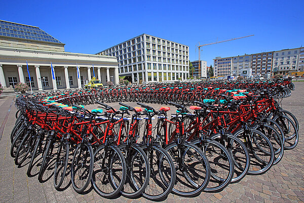 Dutzende Fahrräder stehen in einem Kreis angeordnet auf einem großen Platz