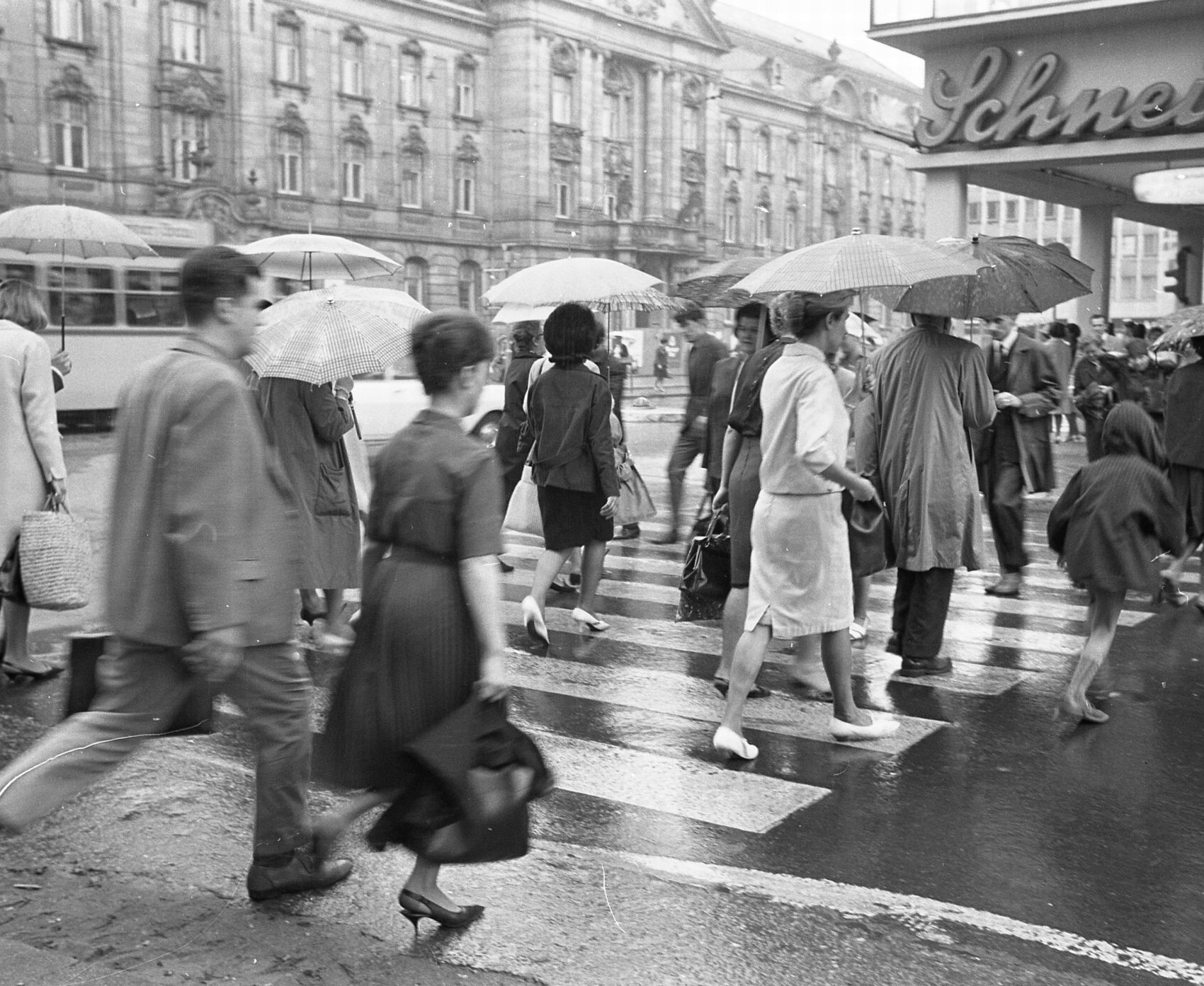 Passanten beim Überqueren der Karlstraße an einem regnerischen Tag im Mai, im Hintergrund die Hauptpost, 1965