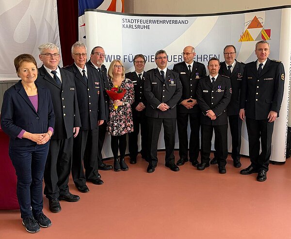 Bürgermeisterin Bettina Lisbach (links), Stadtfeuerwehrverbands-Vorsitzender Ulrich Volz (Dritter von links) und Feuerwehrkommandant Florian Geldner (rechts) ehren außergewöhnliches Engagement und unermüdlichen Einsatz. 