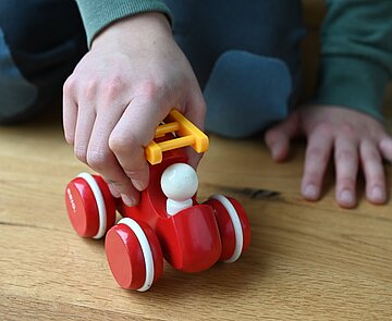 Kind spielt mit einem Spielzeugauto.
