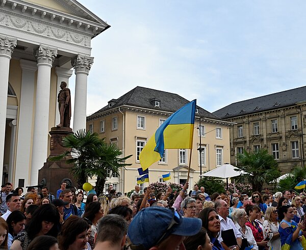 Menschen in ukrainischen Farben gekleidet und mit Ukrainischer Flagge