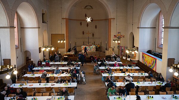 Menschen am Tisch sitzend beim Essen in der Vesperkirche