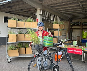 Eine Baumpatin aus der Südstadt nimmt ihr Pflanzpaket entgegen
