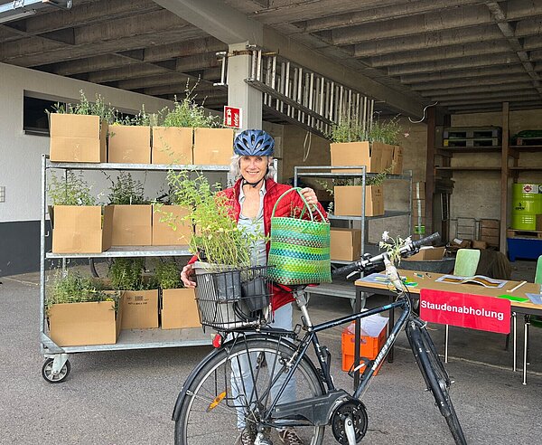 Eine Baumpatin aus der Südstadt nimmt ihr Pflanzpaket entgegen