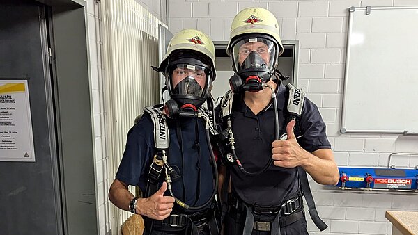 Zwei Personen in Feuerwehrmontur.