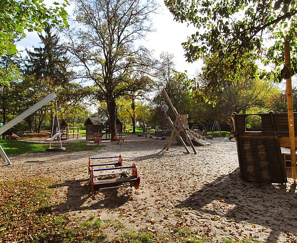 Eine Wippe, eine Reifenschaukel und andere Geräte auf einem Spielplatz