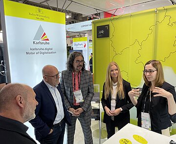 Verkehrsminister Winfried Hermann (2.v.l.) nutzte seine Teilnahme als Sprecher auf dem Kongress, um sich mit einer Delegation am Karlsruher Messestand über das Zusammenspiel von Wirtschaft, Wissenschaft und Netzwerken sowie Verwaltung und Kultur zu informieren.