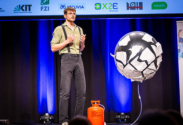 Der Kandidat zeigt seinen Vortrag mit einem großen Ballon, der mit Helium gefüllt wird.