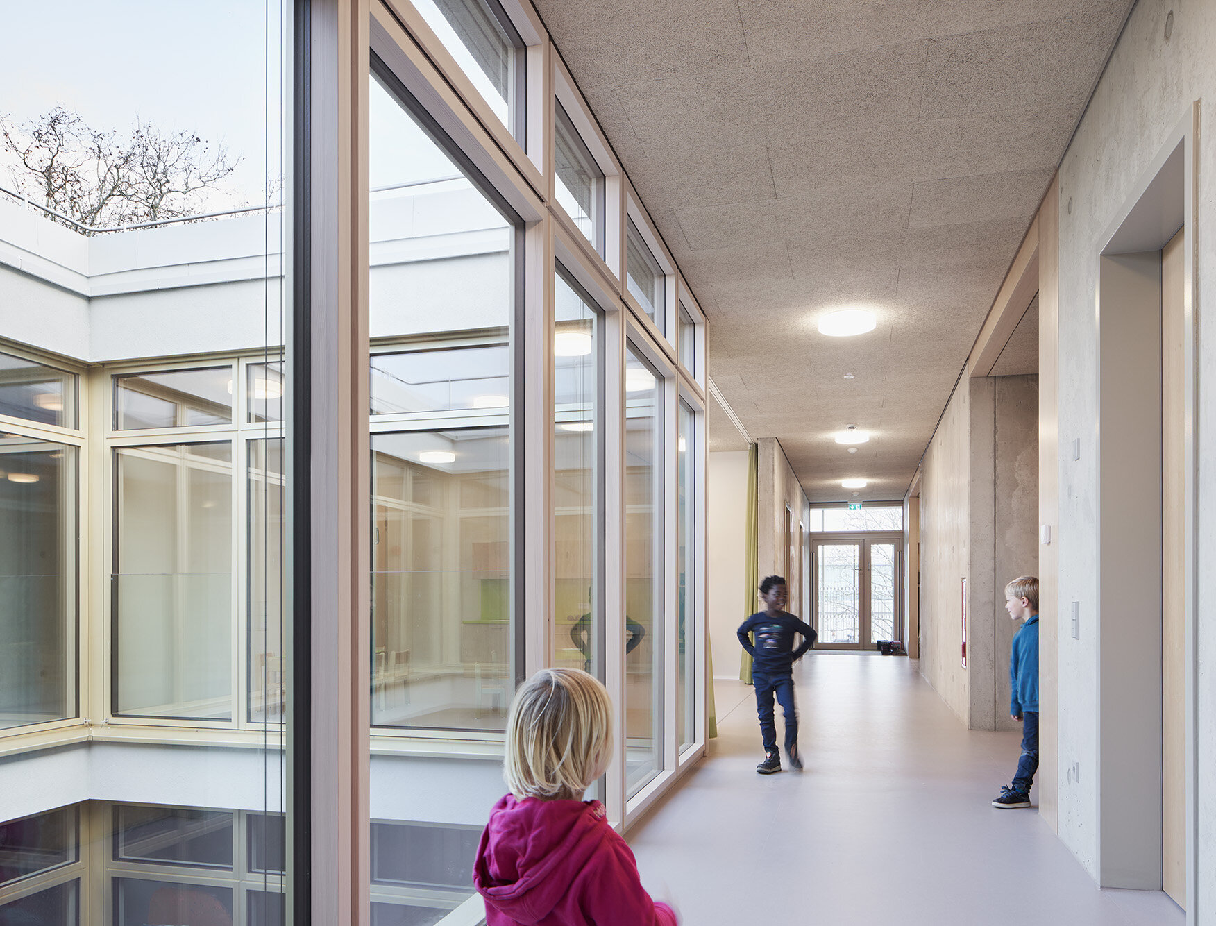 Zu sehen sind Kinder, die sich im hellen Flur im 1.Obergeschoss aufhalten.