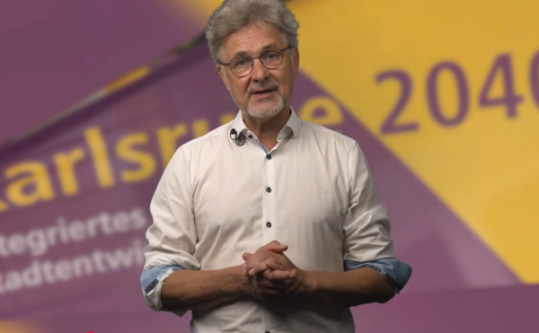 Oberbürgermeister Dr. Frank Mentrup vor dem Hintergrund eines Plakats mit der Aufschrift Karlsruhe 2040
