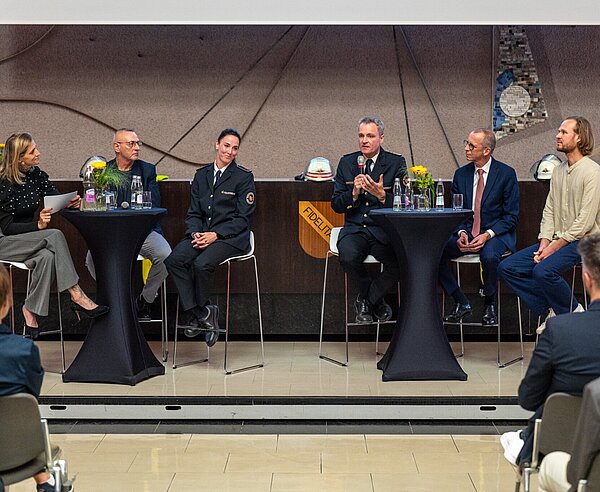 Amtsleiter Florian Geldner, mit Mikrofon, spricht während der Talkrunde im Rathaus am Marktplatz.