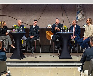 Amtsleiter Florian Geldner, mit Mikrofon, spricht während der Talkrunde im Rathaus am Marktplatz.