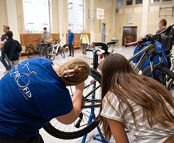 Das Fahrrad einer Schülerin wird  auf Sicherheit gecheckt 