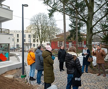 Volkswohnungs-Geschäftsführer Stefan Storz (r.) erläutert beim Presserundgang die verschiedenen Einrichtungen auf dem August-Klingler-Areal