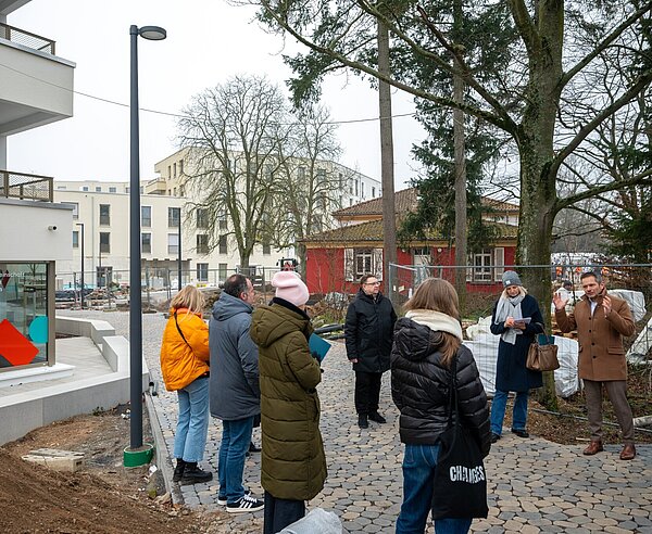 Volkswohnungs-Geschäftsführer Stefan Storz (r.) erläutert beim Presserundgang die verschiedenen Einrichtungen auf dem August-Klingler-Areal