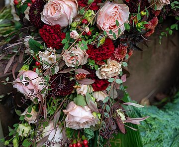 Blumenkranz an Grabstein lehnend