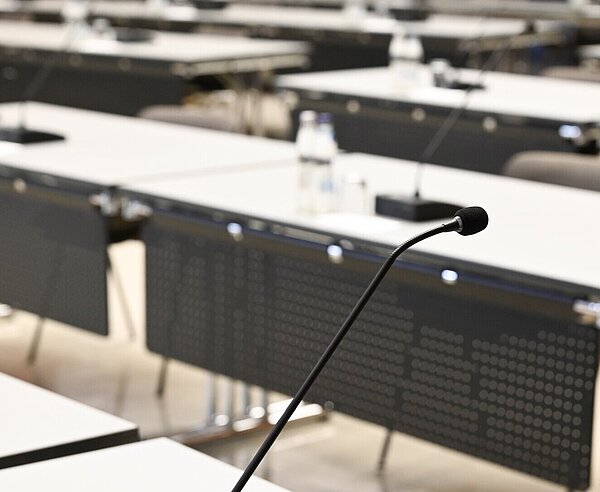 Einzelne Tische mit Mikrofonen im Bürgersaal