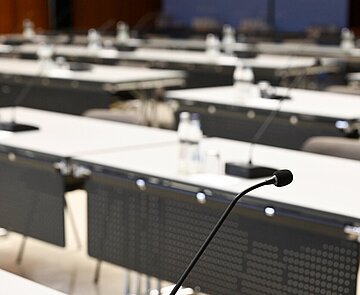 Einzelne Tische mit Mikrofonen im Bürgersaal