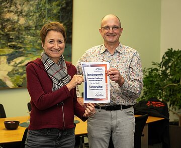 Rainer Romer von „Wattbewerb“ übergibt den Preis an Bürgermeisterin Bettina Lisbach.