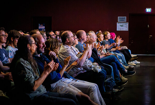 Viele Menschen im FameLab-Publikum klatschen.