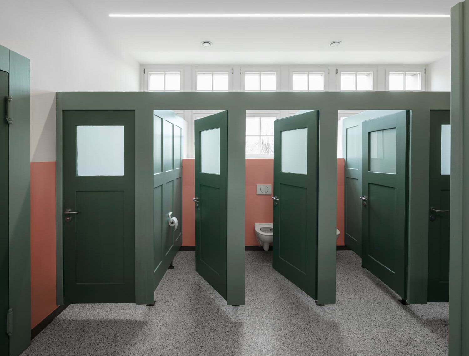 Blick auf Reihe grüner, leicht geöffneter Toilettentüren