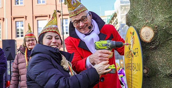 Umwidmung des Christbaums auf dem Marktplatz zum Narrenbaum am 15.02.2025, Dr. Rahsan Dogan (CDU) mit Michael Meier (Präsident Festausschuss Karlsruher Fastnacht e.V.)