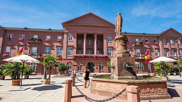 Außenansicht des Rathausgebäudes am Marktplatz mit Brunnen im Vordergrund