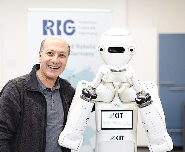 Professor Asfour und ein humanoider Roboter.