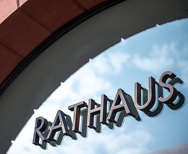 Schriftzug über Glastüre am Eingang zum Rathaus.