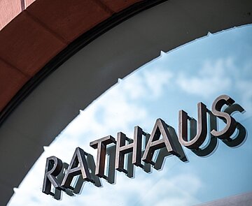 Schriftzug über Glastüre am Eingang zum Rathaus.
