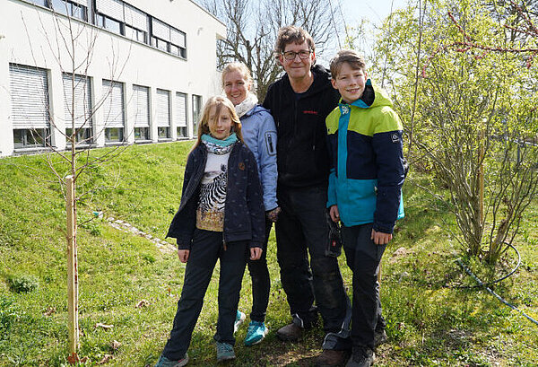Familie Arnold steht zusammen in ihrem Firmengarten