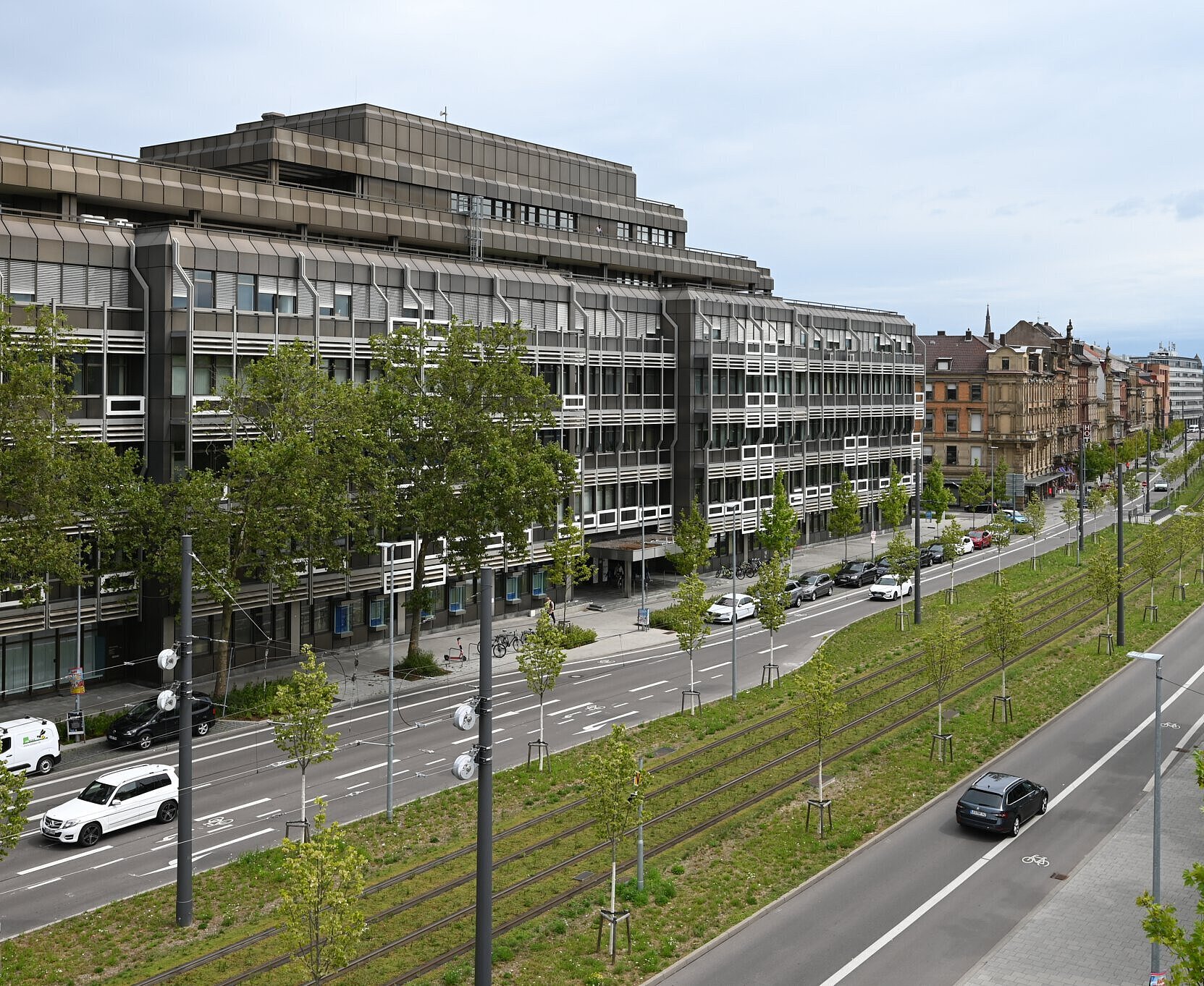 Autos und Bahnen auf der Kriegsstraße östlich des Ettlinger Tors. Die Bahngleise sind begrünt.