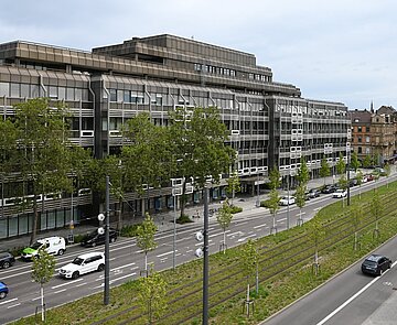 Autos und Bahnen auf der Kriegsstraße östlich des Ettlinger Tors. Die Bahngleise sind begrünt.