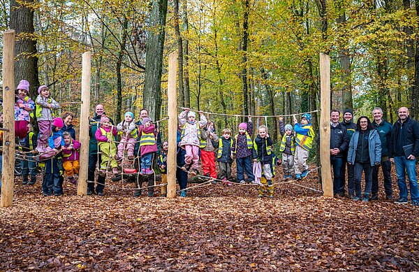 Eine Gruppe des Kindergartens Aufwind aus der Südstadt konnte den Spielplatz bereits erkunden. Eröffnet hatte Bürgermeisterin Bettina Lisbach (4.v.r.) den Spielplatz gemeinsam mit Forstamtsleiter Dr. Stefan Wilhelm (6.v.r.), Zoodirektor Matthias Reinschmidt (6.v.l.) sowie Vertreterinnen und Vertreter des Forstamts und der ausführenden Baufirma Baumann-Trapp (rechts). 
