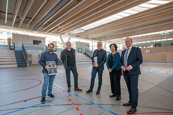 Architekt Lukas Hundhausen, Bauleiter Eckhard Müller-Lüttgen, Thomas Gillich, Ute Stegmann (beide HGW) und Bürgermeister Daniel Fluhrer (v.l.) beim Rundgang in der neuen Sporthalle.