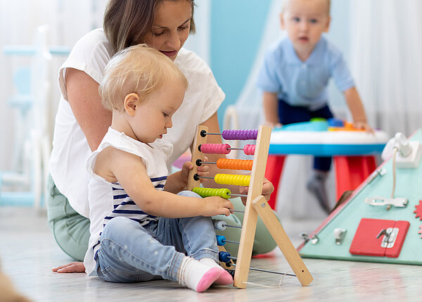 Kinder spielen auf dem Boden mit Lernspielzeugen im Kindergarten.