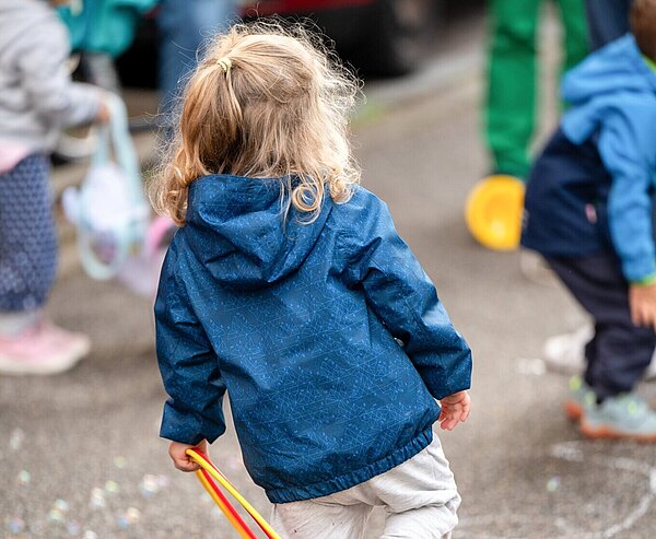Kind spielt auf Straße mit Ring