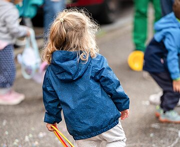 Kind spielt auf Straße mit Ring