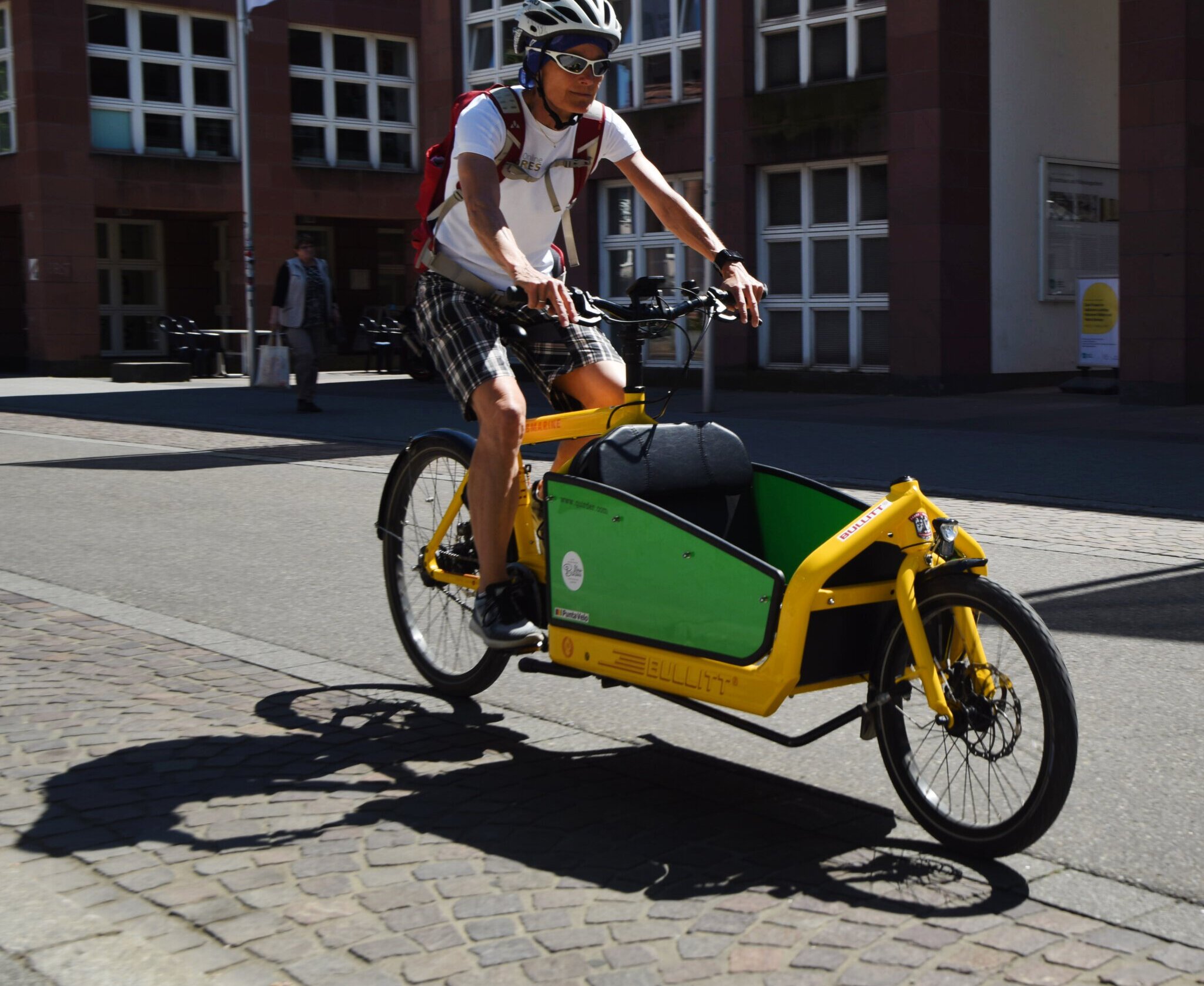 Ein Mann fährt auf einem Lastenfahrrad.